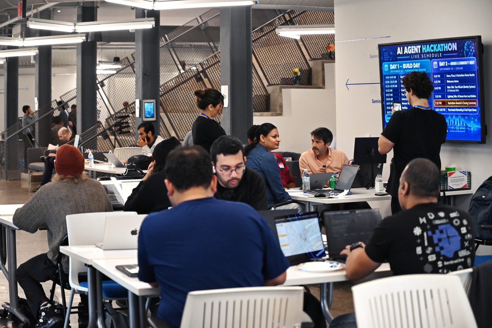 Members building together at tables during the AI Agent Hackathon